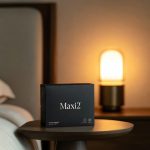 A premium box of Maxi2 longevity supplement on a bedside table under a warm amber smart circadian light setting.