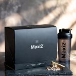A premium packed box of Maxi2 longevity supplement displayed on a dark slate counter next to post-workout cellular recovery elements.